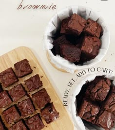 brownies cut into squares in paper bowls next to a cutting board with chocolate on it