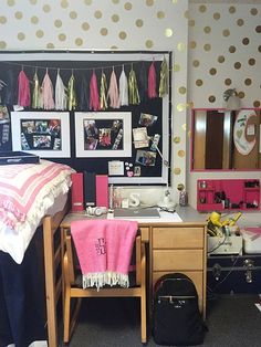 a dorm room with polka dot wallpaper and desk