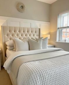 a white bed sitting next to a window in a bedroom