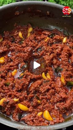 a large pot filled with lots of food on top of a stove next to some vegetables