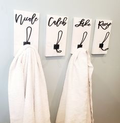 three towels hanging on the wall next to each other with black letters that spell out love