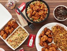 an assortment of chinese food including noodles, chicken and rice with chopsticks on the side