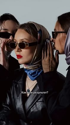 three women wearing sunglasses and scarves are posing for the camera with their heads wrapped around each other