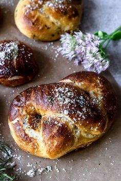 some type of bread with powdered sugar on it next to other pastries and flowers