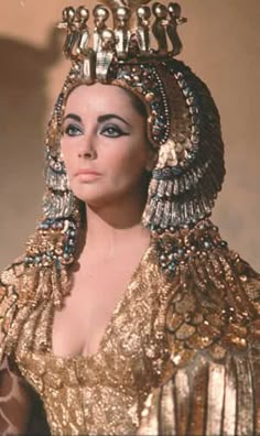 an image of the egyptian queen in gold and white dress with jewels on her head