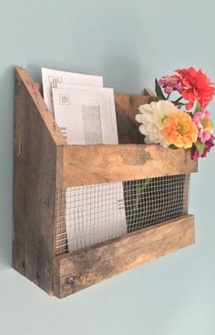 a wooden shelf with flowers and mail in it