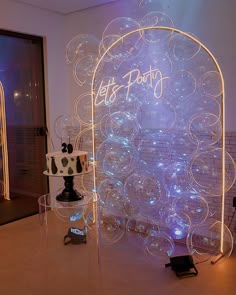 a cake sitting on top of a table next to a glass display case with bubbles