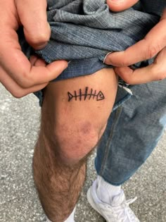 a man with a tattoo on his leg holding onto the arm of another person's knee