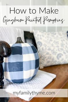 a blue and white pumpkin sitting on top of a wooden table next to pillows with the words how to make gingham painted pumpkins