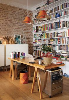 an image of a home office with lots of books on the shelves and desks