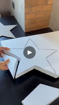 someone is making a star on the floor with foam and glue to make it look like they have been made out of cardboard