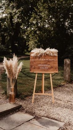 a wooden sign sitting on top of a lush green field