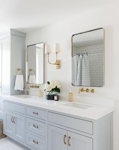 a white bathroom with two sinks and mirrors