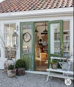 an open door to a shop with potted plants