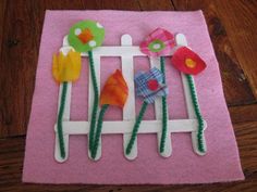 some paper flowers are sitting on top of a piece of felt