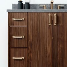 a bathroom vanity with two sinks and wooden cabinets