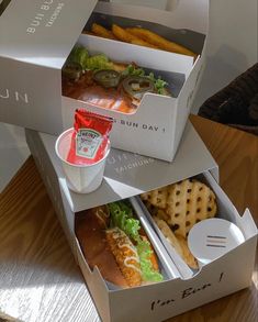 two open boxes with sandwiches and crackers in them