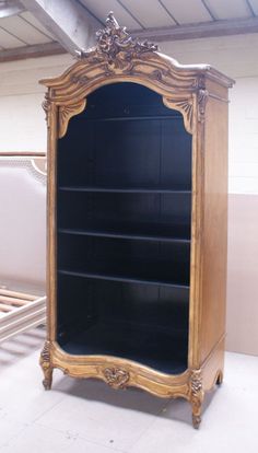 an antique wooden bookcase with black glass doors