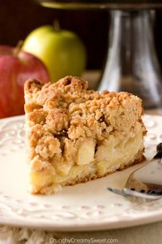 a close up of a slice of pie on a plate with an apple in the background