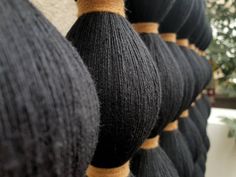 black and brown yarns are lined up on the wall