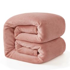 two pink blankets stacked on top of each other in front of a white background,