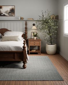 a bed sitting in a bedroom next to a wooden dresser and lamp on top of a hard wood floor