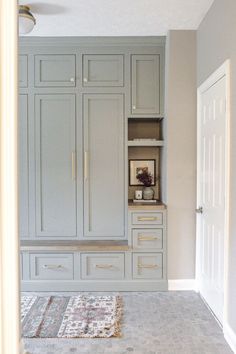 an empty room with gray cabinets and rugs on the floor in front of it