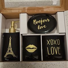 an open box with black and gold items in it, including a bottle of perfume