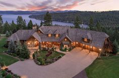 this is an aerial view of a home in the woods at dusk with lights on