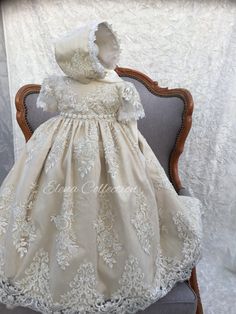 a white dress and bonnet sitting on top of a chair