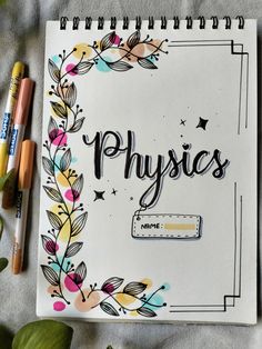 a notebook with the words physics written on it next to some markers and pencils