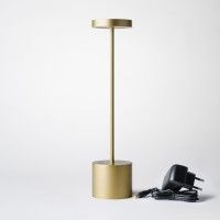 a lamp that is sitting on top of a white table next to a charger