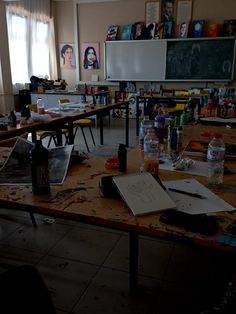 an empty classroom with lots of desks and art supplies on the tables in front of them