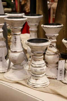 an assortment of white vases are on display