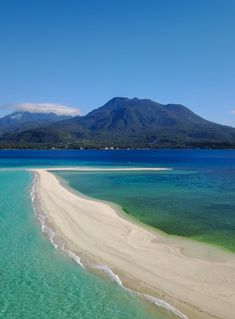 the water is crystal blue and clear, with white sand on the beach in front of it