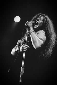 a woman singing into a microphone on stage