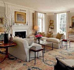 a living room filled with furniture and a fire place in the middle of a room