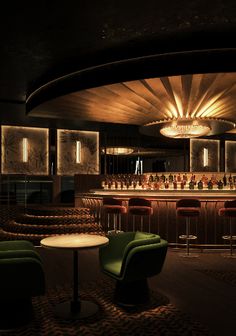 a dimly lit bar with green chairs and stools