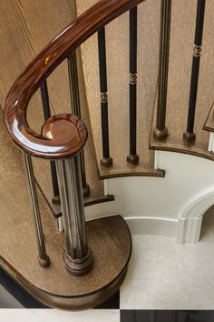 a wooden staircase with metal handrails next to a tiled floor