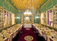 the dining room is set up for a formal function with chandeliers hanging from the ceiling