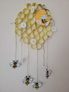 a clock made out of paper with bees and sunflowers hanging from it's sides