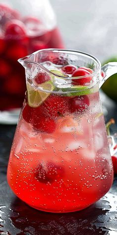 a pitcher filled with liquid and garnished with cherries