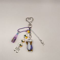 a keychain with an animal and other items attached to it on a white surface