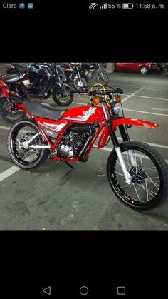 a red dirt bike parked in a parking lot