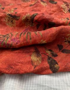 an orange fabric with flowers and leaves on it