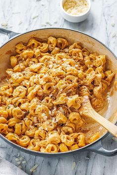 a pan filled with macaroni and cheese sitting on top of a marble counter