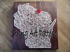 a piece of string art that looks like the state of wisconsin with a red bow