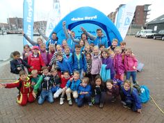 a group of children posing for a photo in front of a sign