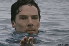 a man is swimming in the water with his hand up