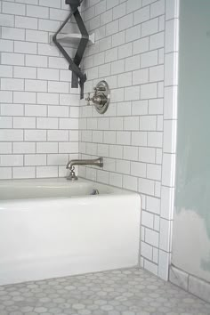 a white bath tub sitting inside of a bathroom next to a toilet paper dispenser